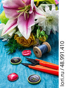 sewing accessories with a bouquet of fresh flowers on turquoise background. Стоковое фото, агентство Ingram Publishing / Фотобанк Лори