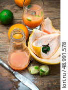 orange tangerine juice on the background of the rind in the rural style. fresh orange juice. Стоковое фото, агентство Ingram Publishing / Фотобанк Лори