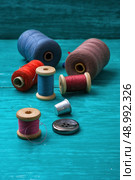 thread buttons for crafts on turquoise wooden background. working tool dressmaker. Стоковое фото, агентство Ingram Publishing / Фотобанк Лори