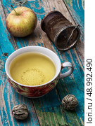 Cup of brewed tea.welding and ripe apple on new background. Cup of apple tea. Стоковое фото, агентство Ingram Publishing / Фотобанк Лори