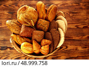 Bread fresh varied mix on golden rustic wood in basket. Стоковое фото, агентство Ingram Publishing / Фотобанк Лори