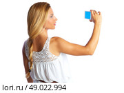 Blond tourist girl taking photos with smartphone on white background and braid. Стоковое фото, агентство Ingram Publishing / Фотобанк Лори