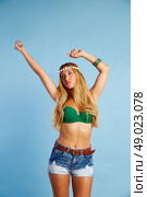 Blond sexy girl with short jeans on blue background and wind in hair. Стоковое фото, агентство Ingram Publishing / Фотобанк Лори