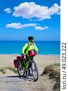 MTB Biker Bicycle touring on a beach with pannier racks and saddlebag. Стоковое фото, агентство Ingram Publishing / Фотобанк Лори