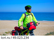 cycling tourist MTB cyclist in Mediterranean beach with paniers and saddlebag. Стоковое фото, агентство Ingram Publishing / Фотобанк Лори