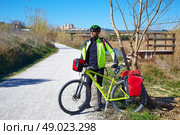 cycling tourist MTB cyclist in Ribarroja Parc de Turia with paniers and saddlebag. Стоковое фото, агентство Ingram Publishing / Фотобанк Лори