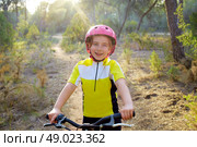 kid girl biker in mountain bike MTB at mediterranean forest. Стоковое фото, агентство Ingram Publishing / Фотобанк Лори