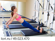 Pilates reformer woman long back stretch exercise workout at gym indoor. Стоковое фото, агентство Ingram Publishing / Фотобанк Лори