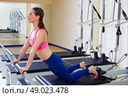 Pilates reformer woman down stretch exercise workout at gym indoor. Стоковое фото, агентство Ingram Publishing / Фотобанк Лори