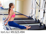 Pilates reformer woman tendon stretch exercise workout at gym indoor. Стоковое фото, агентство Ingram Publishing / Фотобанк Лори