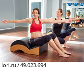 pregnant woman pilates exercise spine twist with Wave corrector and personal trainer. Стоковое фото, агентство Ingram Publishing / Фотобанк Лори