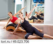 pregnant woman pilates side stretchs exercise with Wave corrector and personal trainer. Стоковое фото, агентство Ingram Publishing / Фотобанк Лори