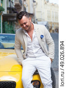 Stylish man smiling near sport car. Стоковое фото, агентство Ingram Publishing / Фотобанк Лори