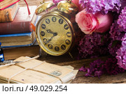 antique  clock with pile of mail. antique alarm clock with pile of mail and flowers. Стоковое фото, агентство Ingram Publishing / Фотобанк Лори