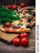 hunk of delicious meat pizza with bacon and olives on the background . Стоковое фото, агентство Ingram Publishing / Фотобанк Лори