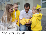 Mom and dad show the children a newborn baby. A baby has appeared in the family. Meeting your newborn brother or sister. Стоковое фото, фотограф Лазаренко Светлана / Фотобанк Лори