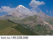 View of Mount Kazbeg in the Caucasus, Georgia. Below the snow-capped peak and the Gergeti glacier, the slopes are deserted and rocky. Стоковое фото, фотограф Лазаренко Светлана / Фотобанк Лори