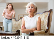 Domestic quarrel between elderly mother and adult daughter in living room. Стоковое фото, фотограф Яков Филимонов / Фотобанк Лори
