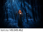 Young witch with staff in night forest. Стоковое фото, агентство Ingram Publishing / Фотобанк Лори