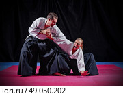 Fight between two aikido fighters on black. Стоковое фото, агентство Ingram Publishing / Фотобанк Лори