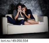 Two crying girls looks TV in dark room. Стоковое фото, агентство Ingram Publishing / Фотобанк Лори