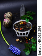 range of exotic teas. Varieties tea infuser spoon with custard on  dark background. Стоковое фото, агентство Ingram Publishing / Фотобанк Лори