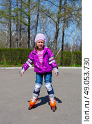 Little girl skating on roller skates at park. Стоковое фото, агентство Ingram Publishing / Фотобанк Лори