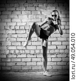Muscular woman on grey brick wall (monochrome version) Стоковое фото, агентство Ingram Publishing / Фотобанк Лори
