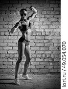 Muscular woman on grey brick wall (monochrome version) Стоковое фото, агентство Ingram Publishing / Фотобанк Лори