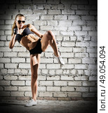 Muscular woman on grey brick wall (dark version) Стоковое фото, агентство Ingram Publishing / Фотобанк Лори