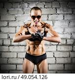 Muscular woman on grey brick wall (dark version) Стоковое фото, агентство Ingram Publishing / Фотобанк Лори