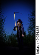 Zombie girl with scythe in night forest. Стоковое фото, агентство Ingram Publishing / Фотобанк Лори