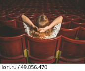 Rear view shot of a young woman sitting alone in an auditorium. Стоковое фото, агентство Ingram Publishing / Фотобанк Лори