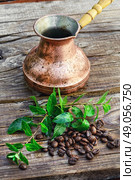 Turk and coffee beans. empty cezve on wooden background with scattered coffee beans and mint. Стоковое фото, агентство Ingram Publishing / Фотобанк Лори