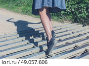A young woman is tripping on a cattle grid in the countryside. Стоковое фото, агентство Ingram Publishing / Фотобанк Лори