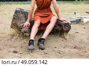 A young woman with bruises on her leg is sitting on a log outside, there is a bicycle in the background. Стоковое фото, агентство Ingram Publishing / Фотобанк Лори