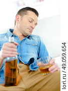 Man asleep holding bottle and glass. Стоковое фото, агентство Ingram Publishing / Фотобанк Лори