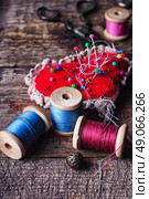 pin cushion with needles,thread and buttons for sewing on stylish wooden background. Стоковое фото, агентство Ingram Publishing / Фотобанк Лори