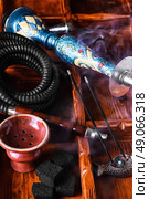Accessories for Shisha. Dismantled parts of hookah on wooden background . Стоковое фото, агентство Ingram Publishing / Фотобанк Лори