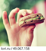 Hipster girl in a cafe eating macaroon. Стоковое фото, агентство Ingram Publishing / Фотобанк Лори