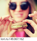 Hipster girl in a cafe eating macaroon. Стоковое фото, агентство Ingram Publishing / Фотобанк Лори
