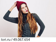 Beauty portrait of a young beautiful girl with long ombre straight hair wearing marsala color warm hat. Magnificent hair. Lips care. Young blonde hipster girl having fun and sending you and kiss. Стоковое фото, агентство Ingram Publishing / Фотобанк Лори