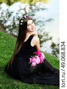 Beautiful hippy bohemian fashion style model in beautiful lake environment. Brunette woman with flowers enjoying nature against nature background. Стоковое фото, агентство Ingram Publishing / Фотобанк Лори