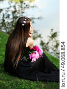 Beautiful hippy bohemian fashion style model in beautiful lake environment. Brunette woman with flowers enjoying nature against nature background. Стоковое фото, агентство Ingram Publishing / Фотобанк Лори