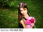 Beautiful hippy bohemian fashion style model in beautiful lake environment. Brunette woman with flowers enjoying nature against nature background. Стоковое фото, агентство Ingram Publishing / Фотобанк Лори
