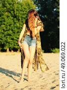 Fashion portrait of beautiful hippie young woman wearing boho chic clothes, chiffon cardigan and boho chic style bijouterie. Blonde haired woman dressed in bohemian style at the beach. Стоковое фото, агентство Ingram Publishing / Фотобанк Лори