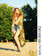 Fashion portrait of beautiful hippie young woman wearing boho chic clothes, chiffon cardigan and boho chic style bijouterie. Blonde haired woman dressed in bohemian style at the beach. Стоковое фото, агентство Ingram Publishing / Фотобанк Лори