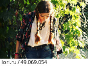 Fashion portrait of beautiful hippie young woman wearing boho chic clothes and summer hat outdoors. Soft warm vintage color tone. Artsy bohemian style. Стоковое фото, агентство Ingram Publishing / Фотобанк Лори