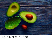 avocado cut on aged wood table board cutted half. Стоковое фото, агентство Ingram Publishing / Фотобанк Лори
