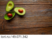 avocado cut on aged wood table board cutted half. Стоковое фото, агентство Ingram Publishing / Фотобанк Лори